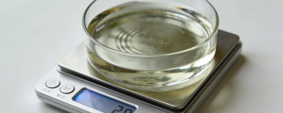Balance avec liquide transparent mesurant masse exacte.