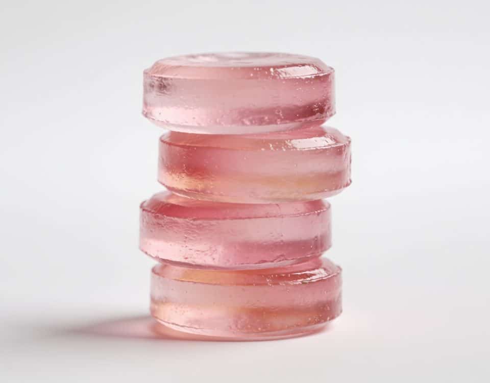 Bonbons roses gélatineux empilés sur surface blanche