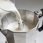 Cafetiere avec liquide blanc versé dedans lentement