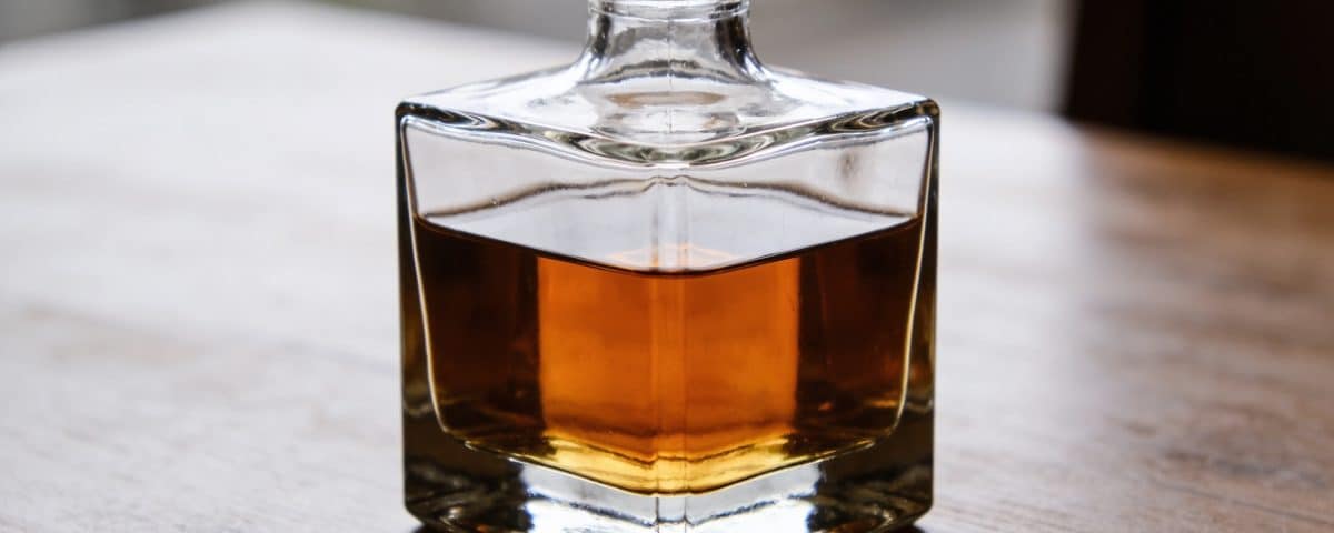 Carafe en verre remplie de whisky ambré sur table
