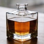 Carafe en verre remplie de whisky ambré sur table
