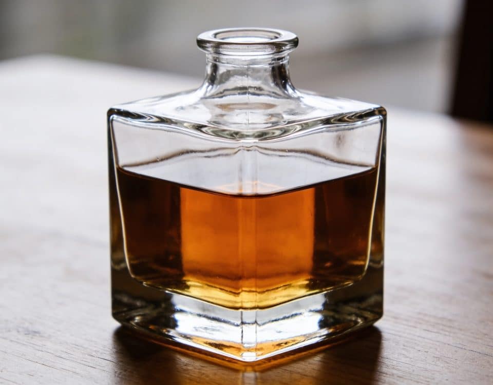 Carafe en verre remplie de whisky ambré sur table