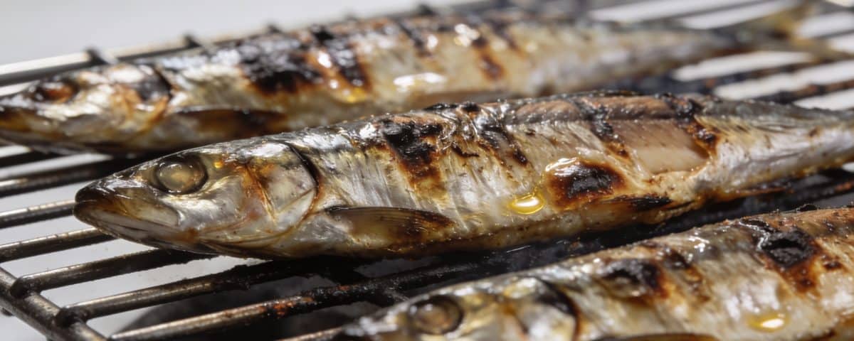 Sardines grillees posees sur grille metallique chaude