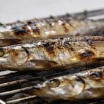 Sardines grillees posees sur grille metallique chaude