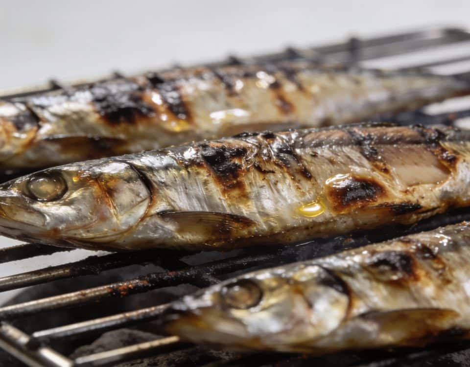 Sardines grillees posees sur grille metallique chaude