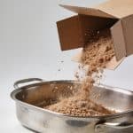Mains versant marrons d'une boîte dans casserole