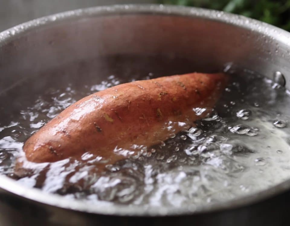 Patate douce entière dans casserole d'eau bouillante.