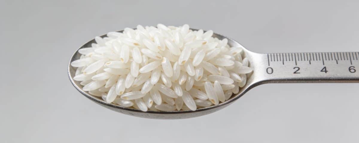 Portion de riz blanc mesuree dans une cuillere graduee