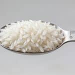 Portion de riz blanc mesuree dans une cuillere graduee