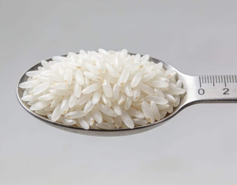 Portion de riz blanc mesuree dans une cuillere graduee
