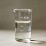 Verre mesureur transparent affichant deux cents millilitres liquide.